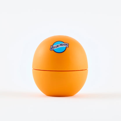 Orange eos-style lip balm container with the Blue Moon logo printed on the front.
